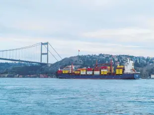  ??  ?? A container ship sails through the Bosporus passing under the Fatih Sultan Mehmet Bridge in Istanbul, Turkey, Feb. 19, 2021.