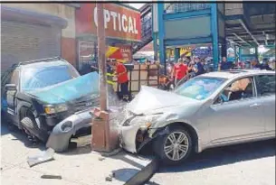  ?? JEROME FORDHAM ?? A parked SUV (left) jumped the curb after being slammed into by a speeding 2011 Infiniti (right) below the 4 train tracks in Fordham Heights, Bronx, on Wednesday.