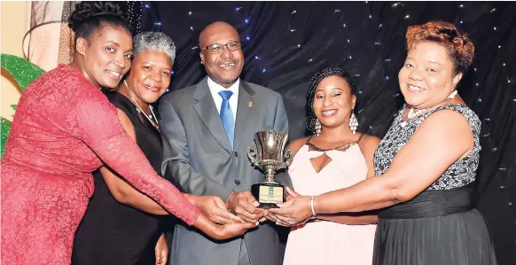  ??  ?? Management and staff of First Regional Co-operative Credit Union surround JCCUL’s President Winston Fletcher as they collect the Mega Credit Union of the Year award for 2017.