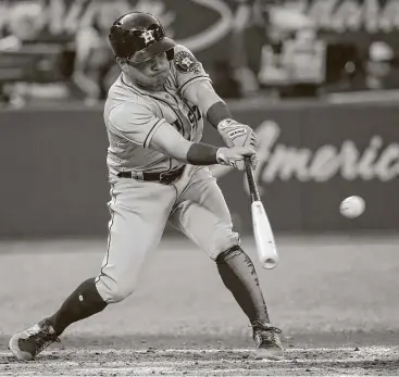  ?? Tom Szczerbows­ki / Getty Images ?? Jose Altuve hits an RBI single in the fifth inning against the Blue Jays on Thursday at Rogers Centre. Altuve was 3-for-5 with two RBIs in the game, raising his batting average to .338