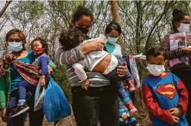  ?? John Moore / Getty Images ?? Migrants seeking asylum wait to be processed by U.S. Border Patrol agents after the group crossed the Rio Grande into Hidalgo, Texas, on March 25.