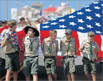  ?? Gary Coronado Los Angeles Times ?? MEMBERS OF Orange County Boy Scouts Troop 227 celebrate the Fourth of July this year in Huntington Beach. Starting next year, girls will be allowed to join the Cub Scouts and eventually become Eagle Scouts.