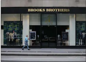  ?? (AP/Frank Franklin II) ?? A pedestrian passes a Brooks Brothers store in New York. The clothier filed for bankruptcy earlier this month.