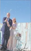 ??  ?? Richard Raney and Laura Eshelman mark their Valentine’s Day wedding by popping the cork on a bottle of sparkling wine.