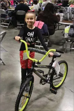  ?? The Sentinel-Record/Tanner Newton ?? NEW BIKE: Lylie Shirley proudly shows the bike that she won Saturday during the 33rd annual Christmas for Kids event at the Hot Springs Convention Center.