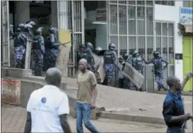  ?? RONALD KABUUBI — THE ASSOCIATED PRESS ?? Ugandan riot police enter a building to chase supporters of Ugandan pop star-turnedlawm­aker Bobi Wine, whose real name is Kyagulanyi Ssentamu, in Kampala, Uganda Friday.