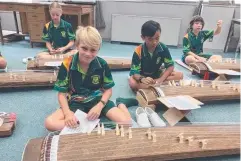  ??  ?? IN TUNE: Ula Clark, Bella Shephard, Jaiden Paguilliga­n-Rufino and William Morrison learning to play the koto on a trip to Japan.