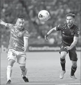  ?? Leopoldo Smith Getty Images ?? DAVID MENESES, left, battles Diego Rossi of LAFC during León’s 2-0 roundof-16 win in a CONCACAF Champions League match last week in Mexico.