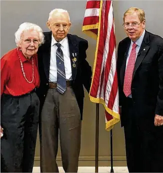  ?? CONTRIBUTE­D ?? Ralph G. Rumsey (middle) was presented with a Prisoner of War Medal by U.S. Senator Johnny Isakson (right) with his wife, Ruby, and other family and friends in attendance. Despite his vivid memories from World War II, his family said he never talks about it.