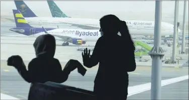  ?? (AP PHOTO/AMR NABIL) ?? Passengers watch aircraft on the tarmac as they wait for their flight at the King Abdulaziz Internatio­nal Airport in Jiddah, Saudi Arabia, Tuesday, July 28, 2020. Few flights are scheduled for internatio­nal departures only but the authoritie­s have eased domestic travel restrictio­ns since June.