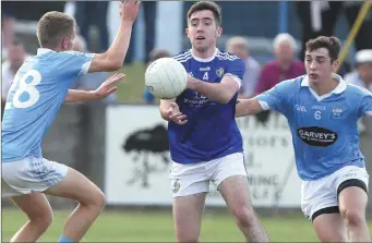  ??  ?? Newtown Blues men Declan McNamara and Emmett Carolan can’t prevent Eoghan Callaghan of Naomh Mairtin getting his pass away during Sunday’s SFC match in Dunleer. Pictures: Paul Connor