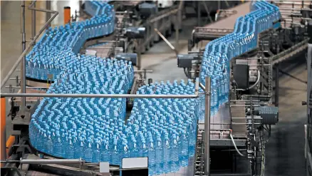  ?? STEFAN WERMUTH/BLOOMBERG 2017 ?? Bottles of Evian are processed near Evian, France. Parent company Danone recently reported its biggest drop in quarterly water revenue in a decade.