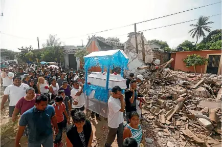  ?? PHOTO: REUTERS ?? People form a procession before the burial of a victim of the earthquake in Juchitan that struck the southern coast of Mexico.
