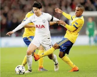  ??  ?? Tottenham Hotspur’s South Korean striker Son Heung-Min (C) squeezes between Juventus’ Brazilian midfielder Douglas Costa (R) and Juventus’ German midfielder Sami Khedira (L) during the UEFA Champions League round of sixteen second leg football match at Wembley Stadium in London yesterday