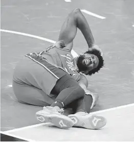  ?? NICK WASS AP ?? Joel Embiid of the 76ers is down on the court after suffering an apparent leg injury on Friday night in Philadelph­ia’s win over the Wizards.