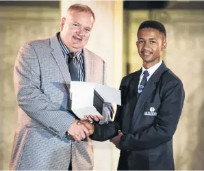  ?? / SUPPLIED ?? Neo Rakuba receives his award of academic excellence from John Bisset, the regional head at Curro Holdings.