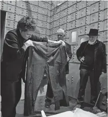  ??  ?? Déballage du pantalon porté par Charlie dans The Kid, en présence de deux de ses fils, Eugene et Michael. À droite: Chaplin écrivant ses mémoires au manoir, 1964. Ci-dessous: Charlot dans City Lights.