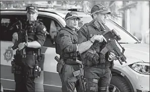  ?? AP/KIRSTY WIGGLESWOR­TH ?? British police officers stand watch Tuesday at Albert Square in Manchester during a vigil for the victims of a suicide bomb attack at a concert Monday.