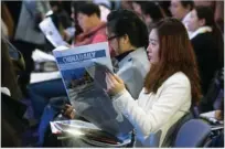  ??  ?? A guest flips through an edition of China Daily Hong Kong during the forum.