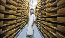  ?? CHRISTINNE MUSCHI / THE NEW YORK TIMES ?? A cheesemake­r in Ste-Elizabeth-de-Warwick, Quebec, inspects products in June. As part of the trade deal signed Sunday with the U.S., Canada will reduce barriers for U.S. dairy farmers to sell cheese, milk and more to Canada.