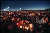  ?? GERALD HERBERT — THE ASSOCIATED PRESS FILE ?? People attend a candleligh­t vigil for the victims of the Wednesday shooting at Marjory Stoneman Douglas High School, in Parkland, Fla., Feb. 15, 2018. After a gunman murdered 14students and three staff members at Parkland's Marjory Stoneman Douglas High School, their families were left with a burning question: How do we go on with our lives while honoring our loved one's memory?