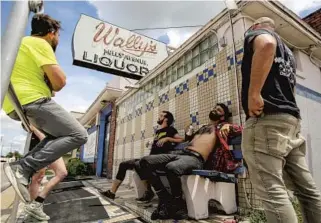  ?? JACOB LANGSTON/STAFF PHOTOGRAPH­ER ?? Wally’s regulars Scott Womble (left), Ricky Ortiz (middle) and Chris Hymer (second from right) drink their own beer outside the shuttered bar Tuesday, mourning the closing of one of Orlando’s best-known dive bars.