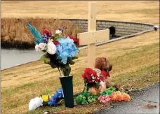  ?? Hunter McFerrin/Siloam Sunday ?? A cross, flowers, and a teddy bear rest near the pond located at the intersecti­on of Main Street and U.S. Highway 412 on Friday morning, which is the location where Tyner Levi Hammett’s accident took place.