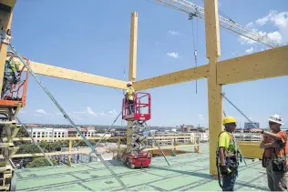  ?? Photos by Rebecca Slezak / Staff photograph­er ?? A constructi­on crew works on the Soto at Broadway and Eighth downtown this month. The six-story office building is the first large-scale mass timber project in Texas.