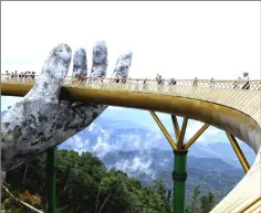  ??  ?? Strolling along the 150-metre long Cau Vang “Golden Bridge” featuring two giant concrete hands.