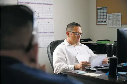  ?? GABRIELA CAMPOS/THE NEW MEXICAN ?? Lt. Paul Joye meets with Detective Paul Ytuarte, foreground, in his office on Friday afternoon. Joye oversees the detectives at work on three recent unsolved homicides in Santa Fe. ‘The detectives, we get to know [a victim’s] families, we get to know their friends,’ Joye said. ‘We take this stuff home with us.’