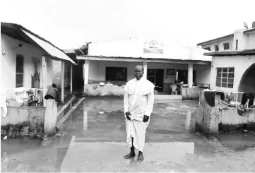  ??  ?? Head of Celestrail Church of Christ at the neighbourh­ood Prophet Taiwo Adesanya stands in front of a church, where valuables were stolen by a gang dubbed the Badoo, after killing worshipper­s.