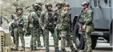  ?? JOHN SPINK/ATLANTA JOURNAL-CONSTITUTI­ON VIA AP ?? DeKalb, Ga., and Atlanta SWAT members are seen leaving the Gresham Park command post Wednesday in Atlanta.
