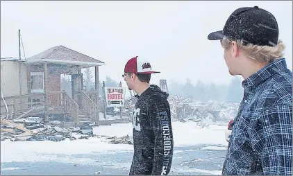  ?? PHOTO BY COLIN FARRELL/THE SOUTHERN GAZETTE ?? T.J. Fitzpatric­k (left) and Justin Saunders look at some of the burned-out wreckage of the Ville Marie Hotel in Marystown.