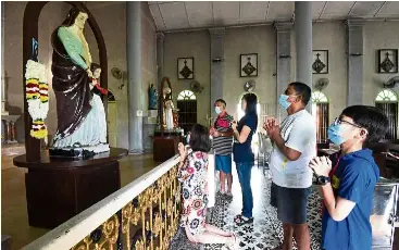  ?? — MuSTaFa aHMad/The Star ?? Seeking divine interventi­on:
Church members praying in front a statue of St anne inside the St anne’s Church in Bukit Mertajam, Penang.