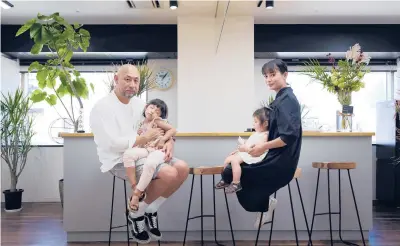  ?? OKAHARA/THE NEW YORK TIMES KOSUKE ?? Takayuki Miyabe holds his daughter Karen, whose seizures from a rare form of epilepsy are treated with CBD oil. Also seen are his wife, Keiko, and daughter, Yuri, on Sept. 25 in Kobe, Japan. The Miyabes are developing their own line of CBD oil.