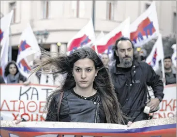  ?? PETROS GIANNAKOUR­IS / ASSOCIATED PRESS ?? Members of a communist-affiliated union march in central Athens on Friday to protest a government decree calling on state entities to lend their cash reserves to the government.