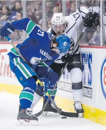  ?? — THE CANADIAN PRESS ?? Vancouver Canucks defenceman Ben Hutton and Los Angeles Kings centre Tyler Toffoli battle for the puck during Tuesday’s 6-2 Canucks win at Rogers Arena.