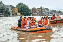  ??  ?? Uttar Pradesh Chief Minister Yogi Adityanath rides on an inflated boat as he visits the flood-affected areas following heavy monsoon rainfall, in Varanasi, last Friday