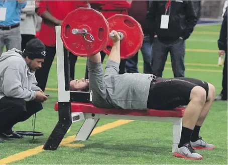  ?? JOHN MAHONEY/FILES ?? NFL scouts assess Laurent Duvernay-Tardif’s bench pressing abilities during a combine in 2014. Players believe scoring well in the standardiz­ed physical tests will result in a greater chance of being drafted, but that doesn’t necessaril­y translate into athletic success on the field.