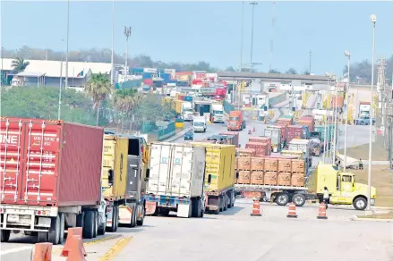  ??  ?? Se formó una larga fila de unidades en el acceso al puerto