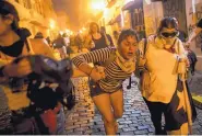  ?? BLOOMBERG PHOTO BY XAVIER GARCIA ?? Demonstrat­ors clash with police officers during a protest calling for the resignatio­n of Gov. Ricardo Rossello in San Juan, Puerto Rico, on Wednesday.