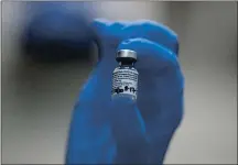  ?? FRANK AUGSTEIN — THE ASSOCIATED PRESS ?? A nurse holds a vial of the Pfizer-BioNTech COVID-19 vaccine at Guy’s Hospital in London on Tuesday. U.K. health authoritie­s rolled out the first doses of a widely tested and independen­tly reviewed COVID-19 vaccine.