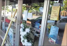  ?? Daniel Bell ?? Cards, flowers and a wooden cross form a memorial in front of Jimmy Payne’s Coast to Coast Home and Auto in Downtown Calhoun after the businessma­n died on Monday.