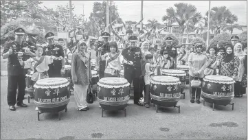  ??  ?? Mazlan (sixth from left) visiting Sibu Police HQ. In the background are the pupils from SJK Sacred Heart Chinese performing the 24-drums to welcome him.