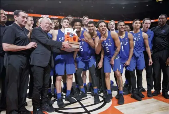  ?? CRAIG MITCHELLDY­ER — THE ASSOCIATED PRESS ?? Nike founder Phil Knight presents the championsh­ip trophy to Duke head coach Mike Krzyzewski, left, after an NCAA college basketball game against Florida in the Phil Knight Invitation­al tournament in Portland, Ore., Sunday. Duke won 87-84.