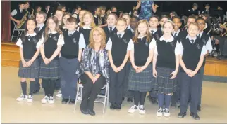  ?? STAFF PHOTOS BY JAMIE ANFENSON-COMEAU ?? St. Mary’s Bryantown Catholic school teacher Michelle Truss sits for pictures with her students following a surprise assembly in which Truss was announced as a 2017 Golden Apple recipient by the Archdioces­e of Washington.