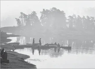  ?? CP PHOTO ?? Smoke blankets the area as Ministry of Natural Resources firefighte­rs work a boat at Flat Rapids Camp and Resort on the French River near Killarney, Ont., on Tuesday.