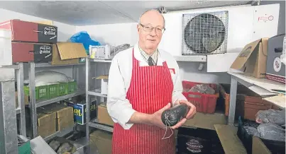  ?? Picture: SWNS.com. ?? Butcher Chris McCabe with the life-saving black pudding at his shop in Totnes, Devon.