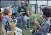  ?? ?? Bay Area Music Project teaching artist Kevin Robinson leads a musical mirroring lesson with second grader Jet Slota, left, and third grader Jordan Singleton at Alameda's Maya Lin School.