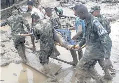  ??  ?? GRIM DISCOVERY Soldiers carry the body of a victim in Mocoa yesterday after mudslides devastated the region